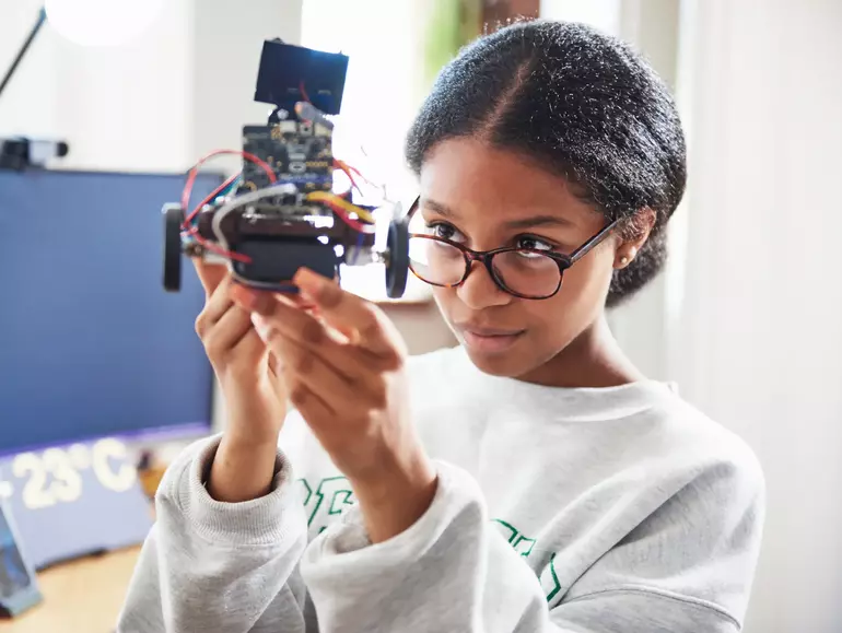 Teenage girl building robot