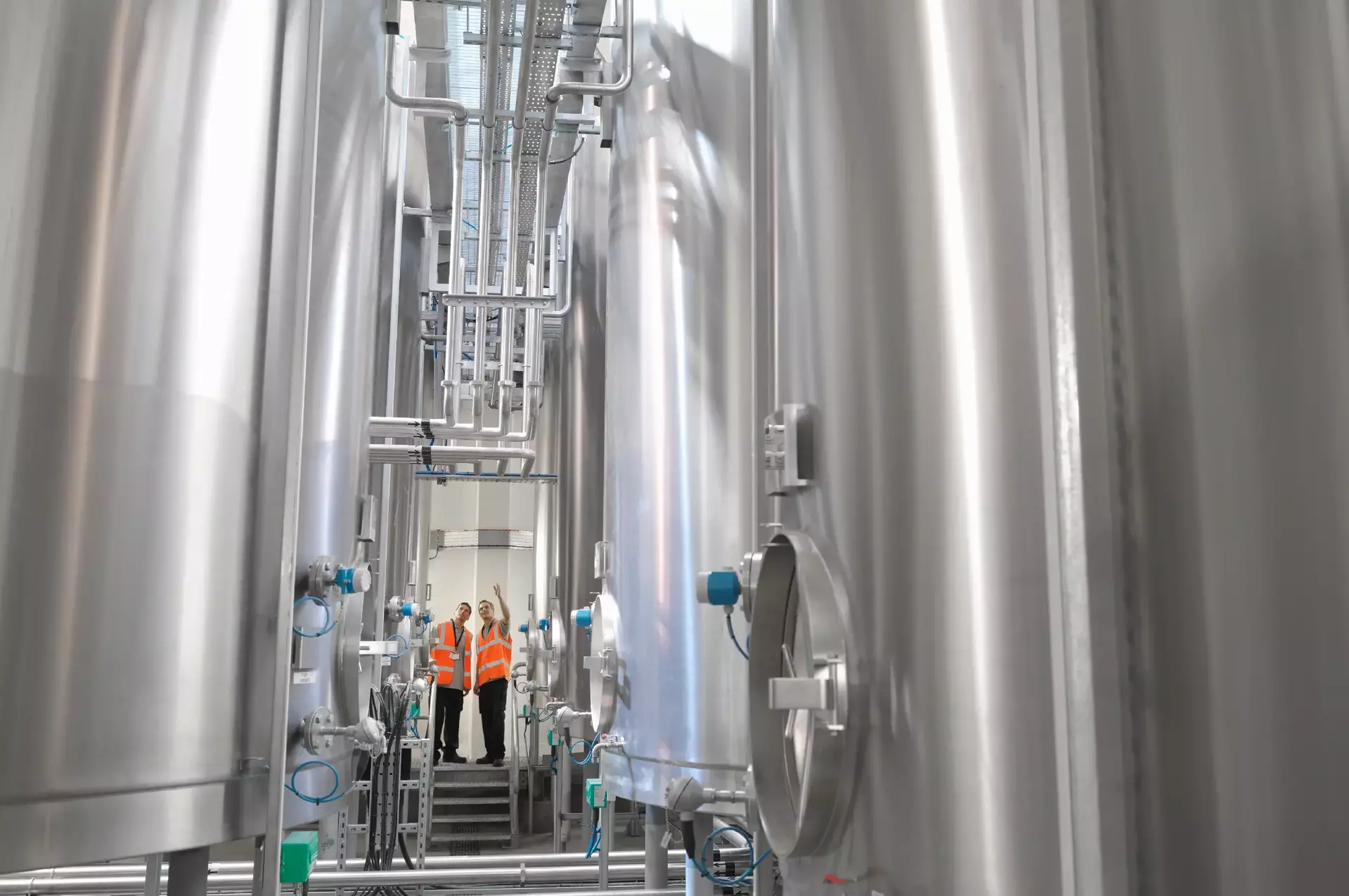 Factory workers examining storage tanks