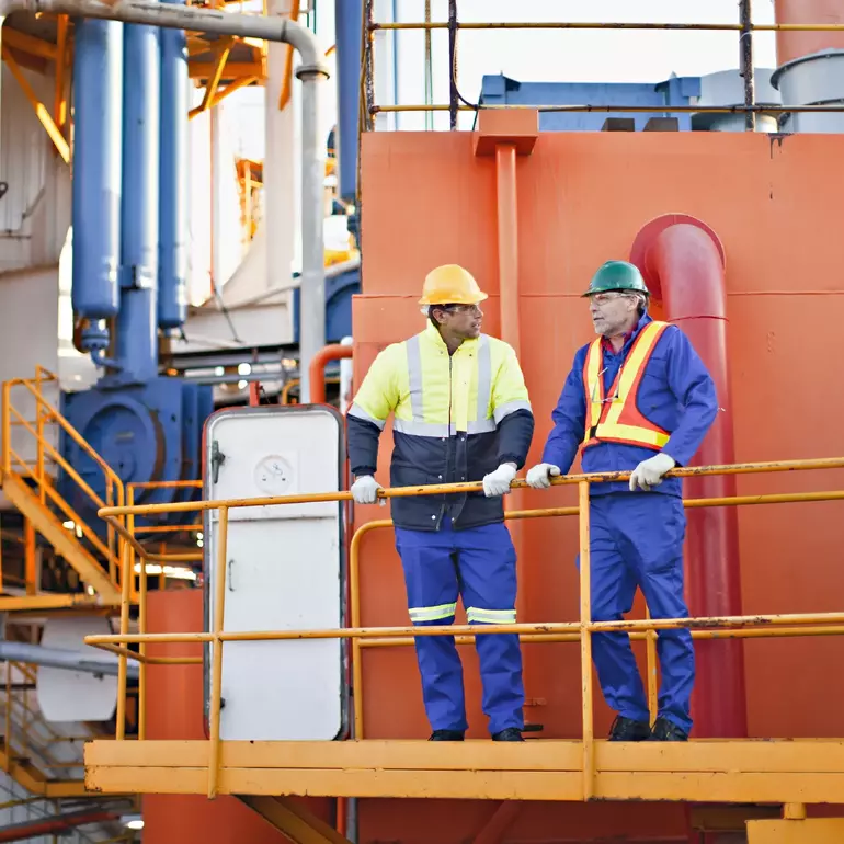 Workers talking on oil rig