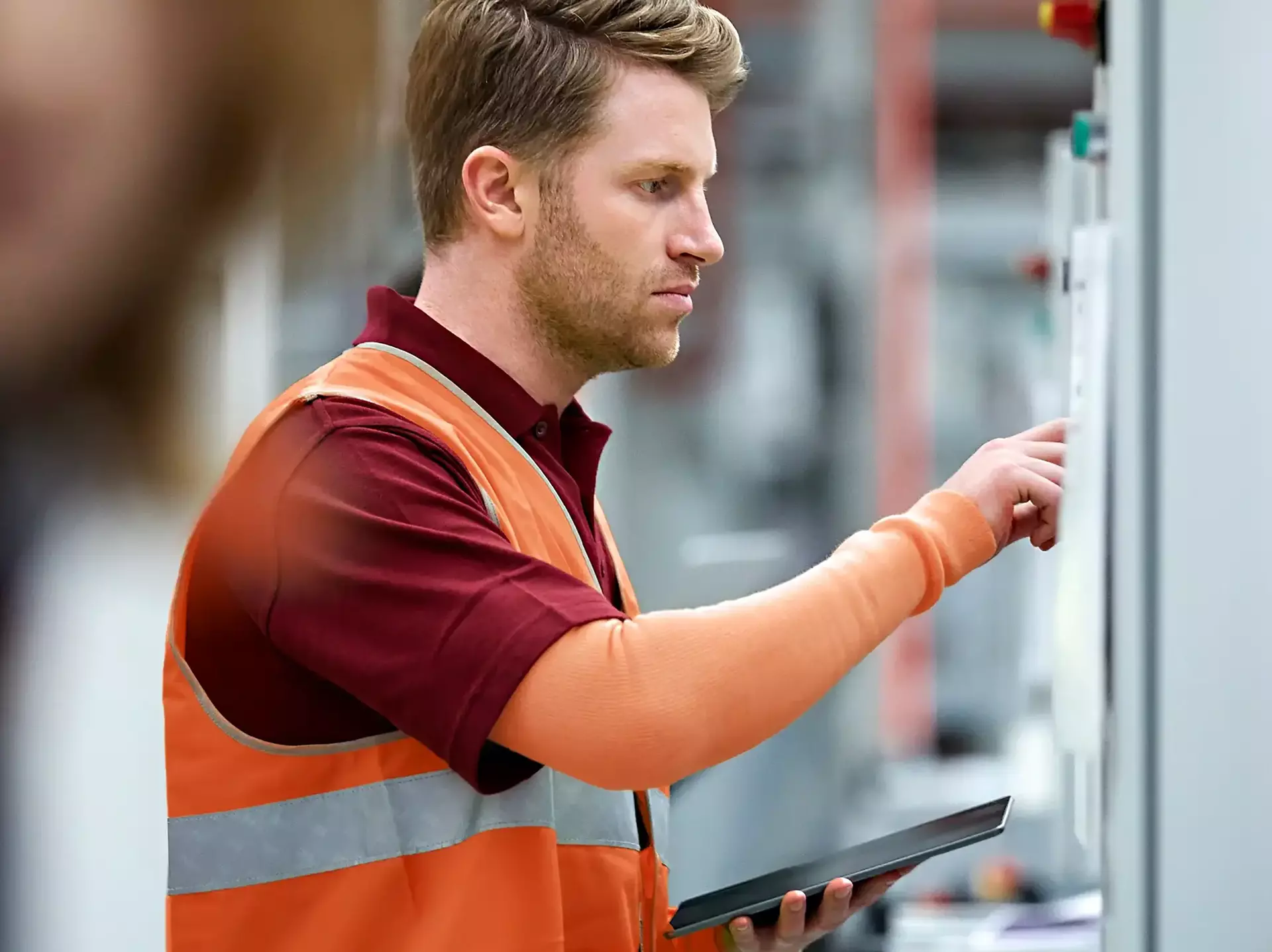 Male engineer using control panel in car plant