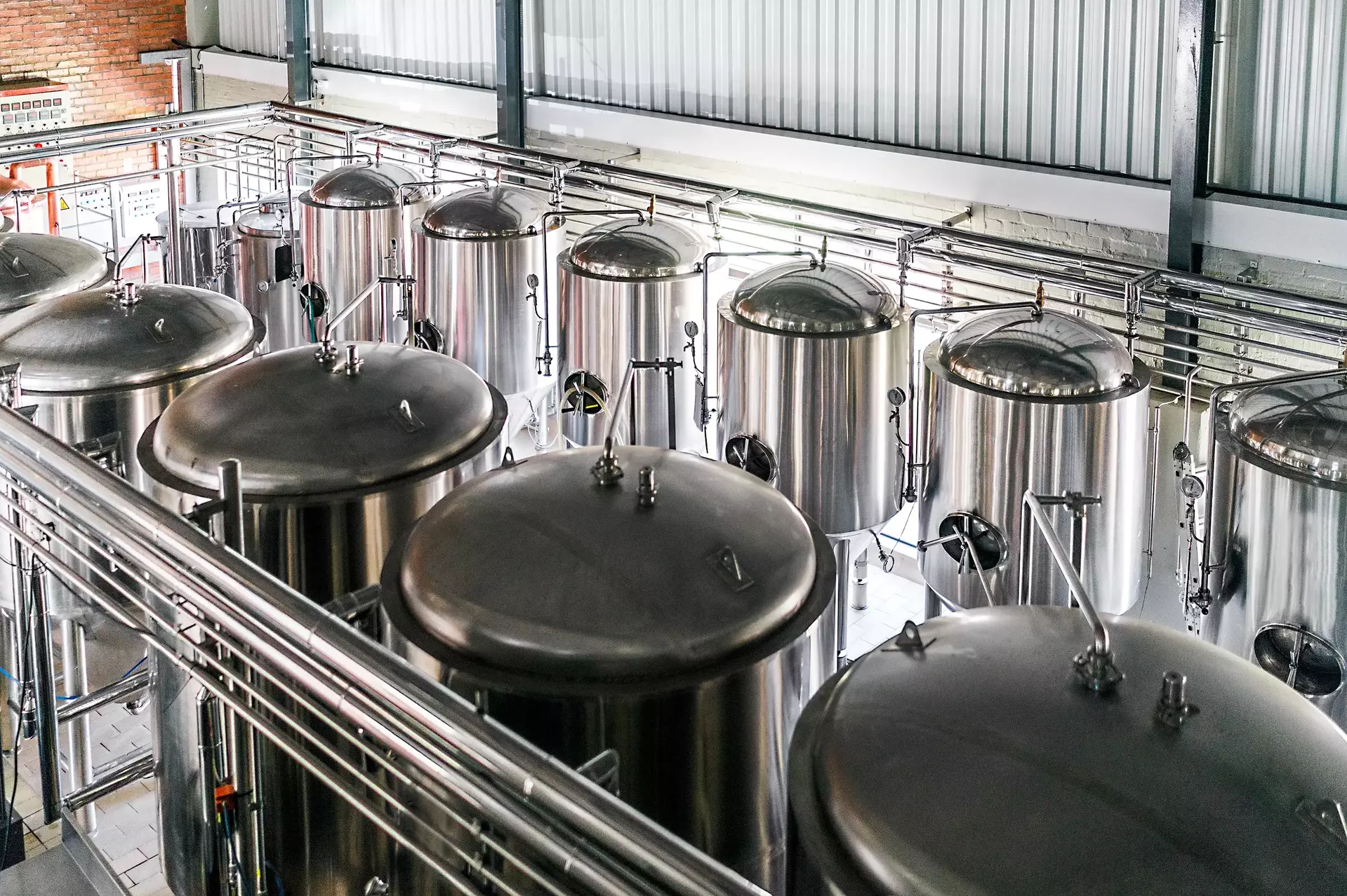 Metallic vats in brewery high angle view of steel containers in factory beer is stored in huge storage tanks at industry