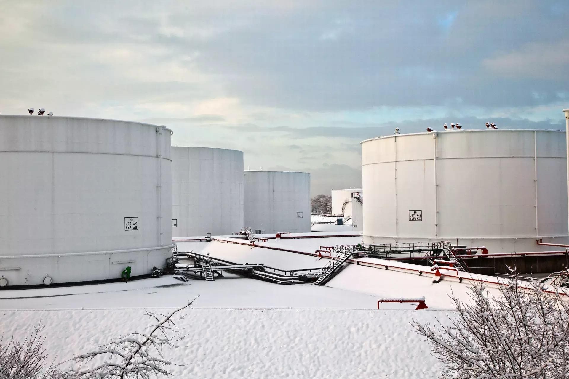 Weißöltanks im Tanklager mit Schnee im Winter