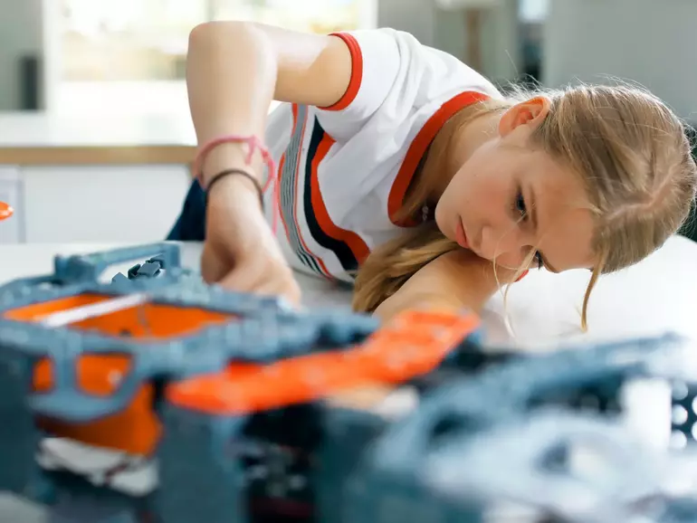 Girl building a robot in workshop