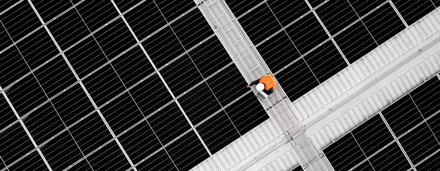 High angle view of engineer holding digital tablet to analysis data of photovoltaic panel system during installation on roof