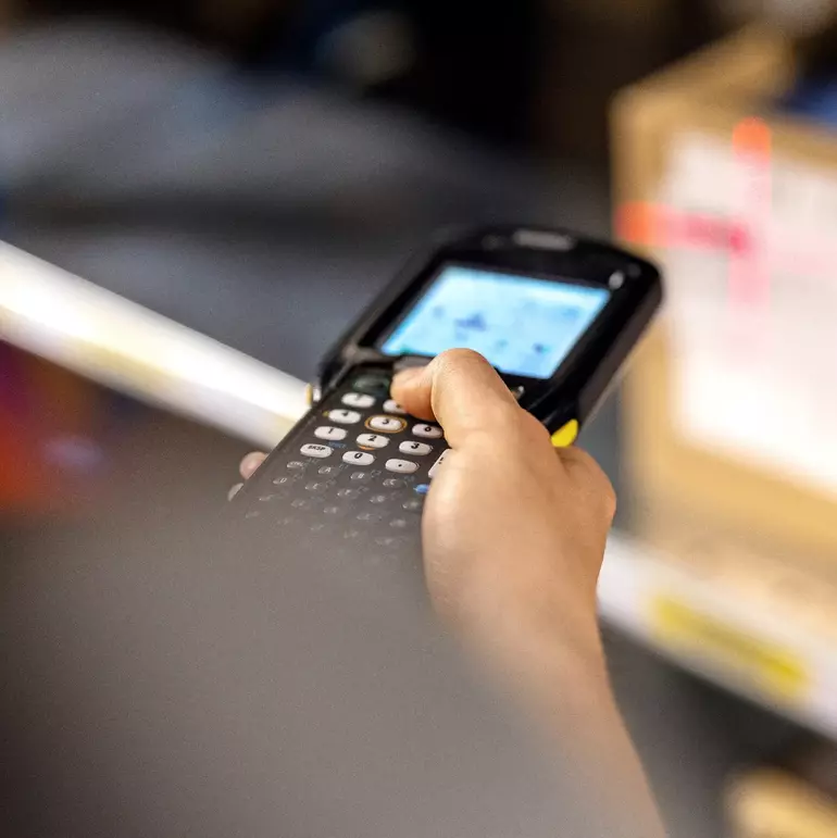 Close up of a warehouse worker scanning boxes in rack