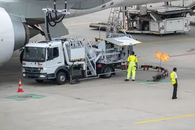 Workers at the airport refueling an airplane