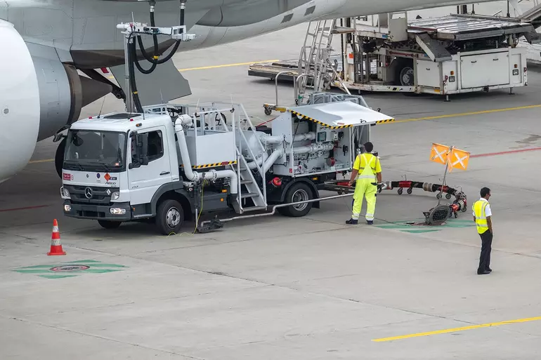 Workers at the airport refueling an airplane