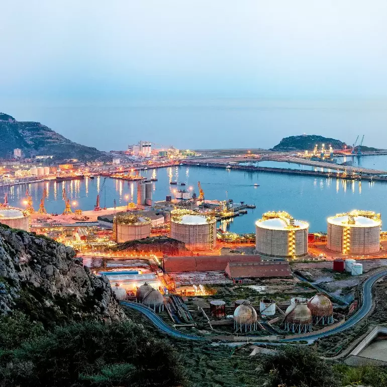 Petrochemical plant and oil refinery industry by the sea at sunset