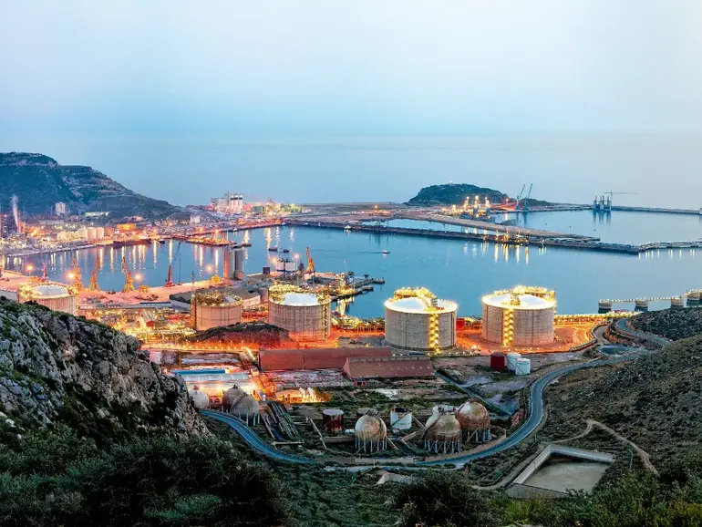 Petrochemical plant and oil refinery industry by the sea at sunset