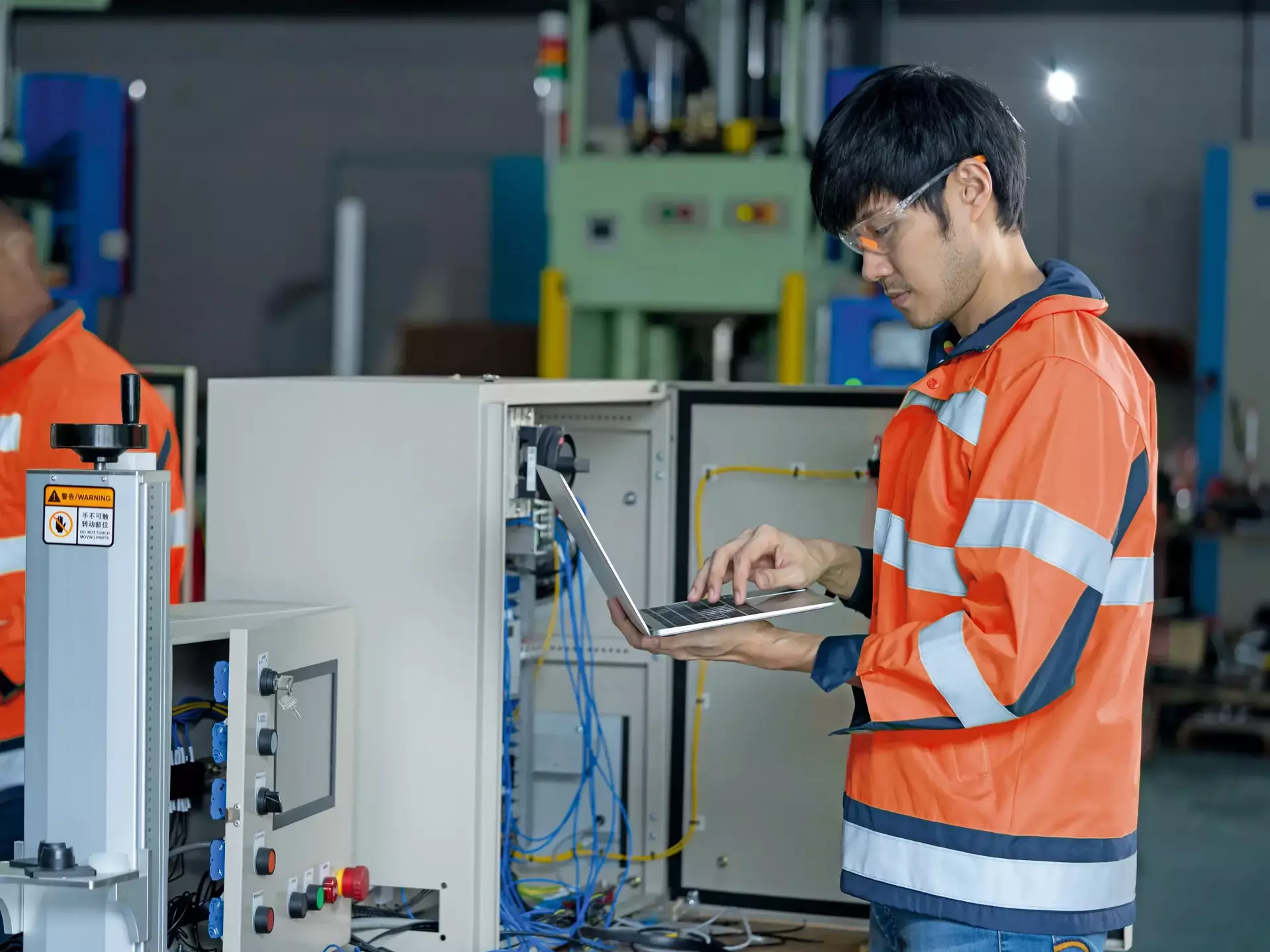 Two  men testing control cabinet for automation