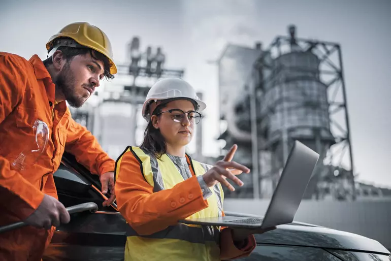 Ein Team von Ingenieuren arbeitet in einer Nachtschicht vor einem Gaswerk