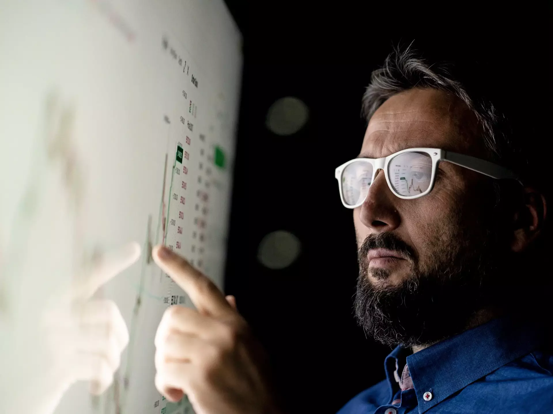 Businessman looking at graph on smart glass panel