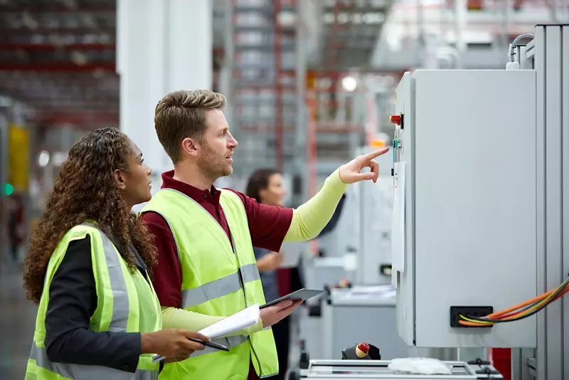 Engineers using control panel in plant