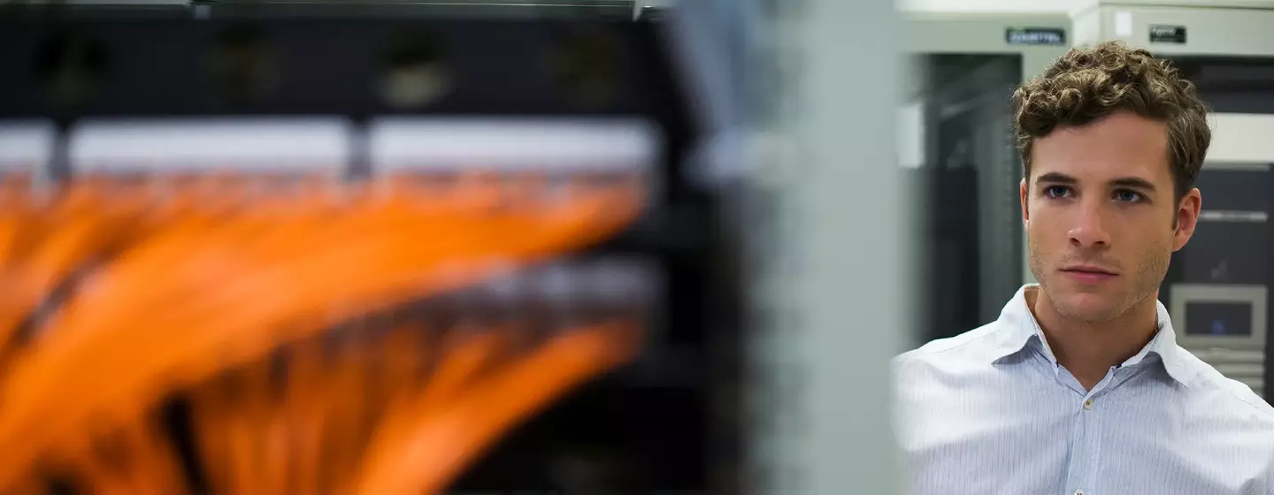 Computer technician using digital tablet performing mainentance check of mainframe equipment