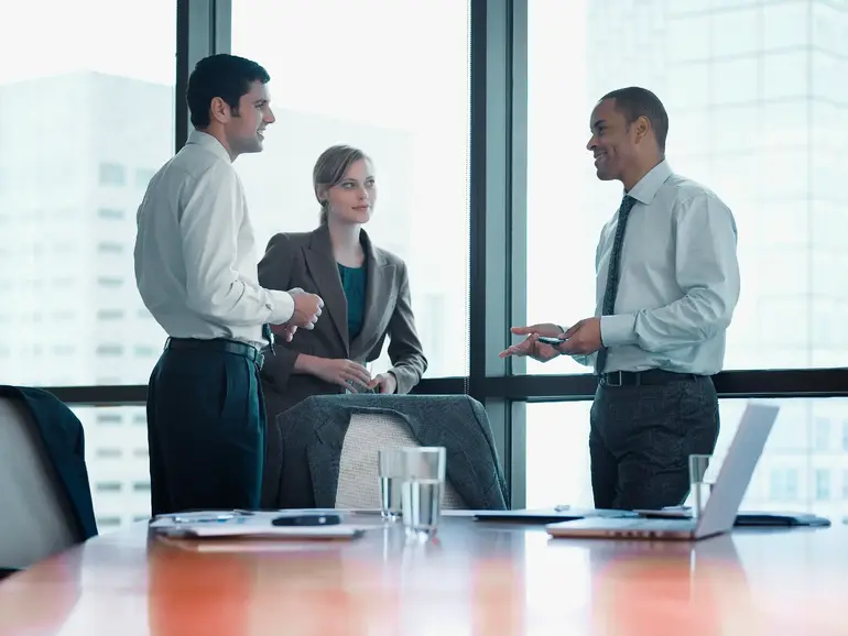 Three businesspeople standing in a boardroom