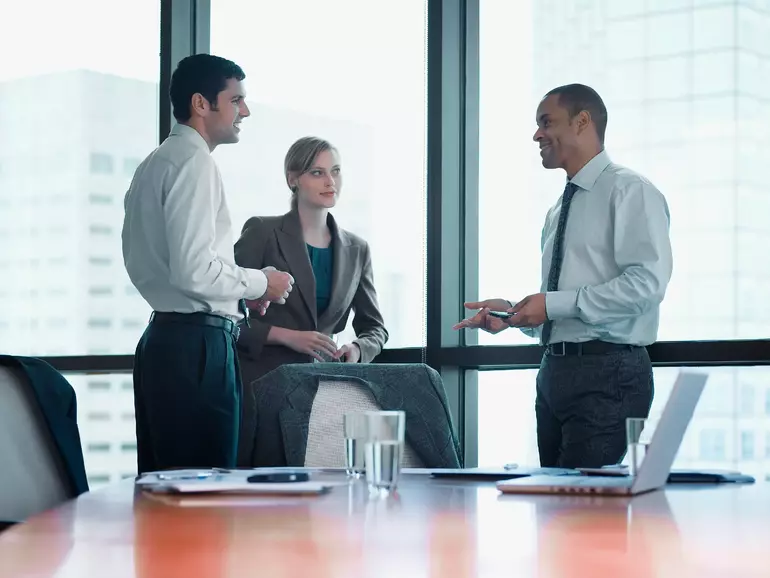 Three businesspeople standing in a boardroom