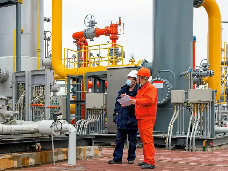 Engineers and staff communicate on site in chemical plant