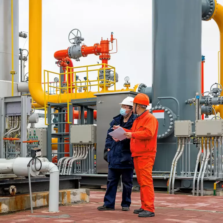 Engineers and staff communicate on site in chemical plant