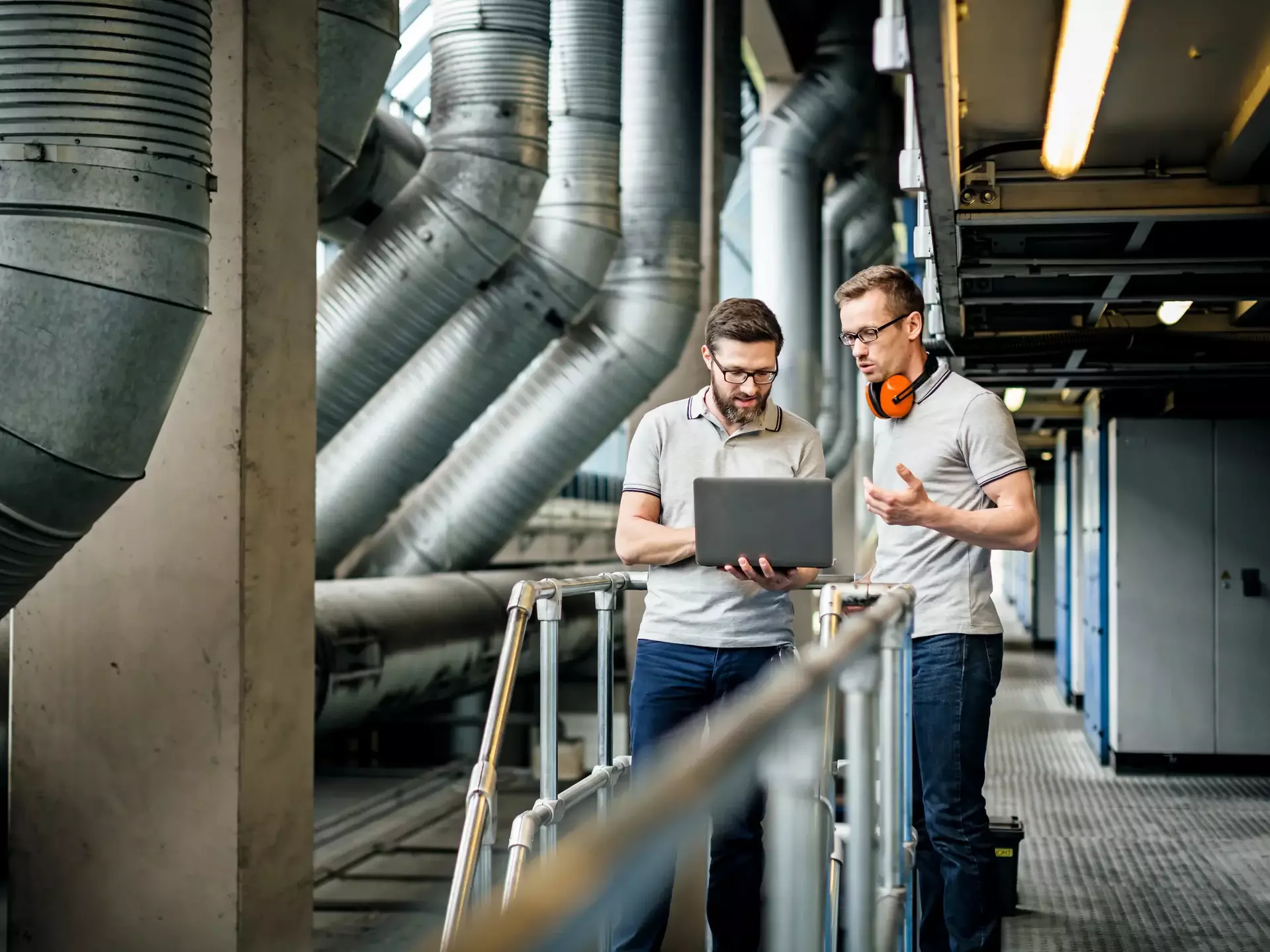 Two engineers with laptop in large printery