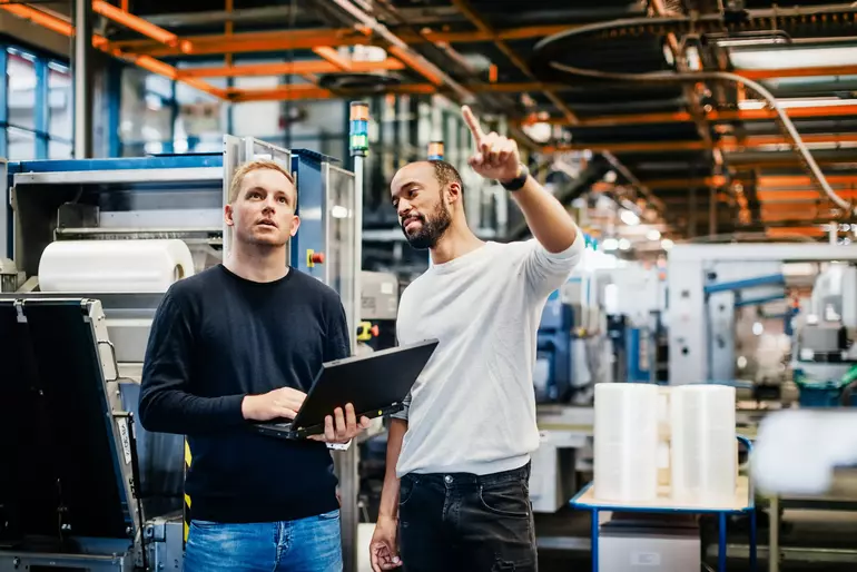 Two engineers discussin machinery maintenance